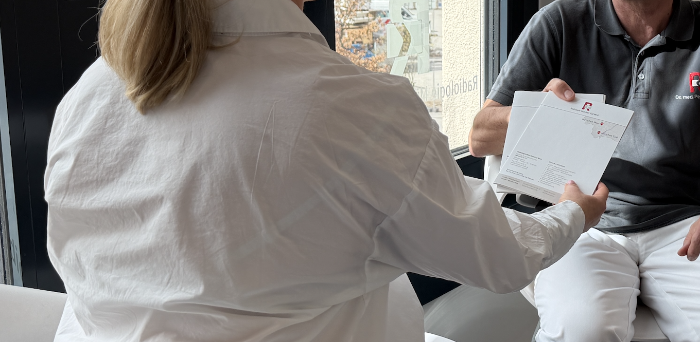 Patientin erhält Informationsunterlagen zur radiologischen Zweitmeinung im Gespräch mit Radiologen in der Radiologie München Süd West