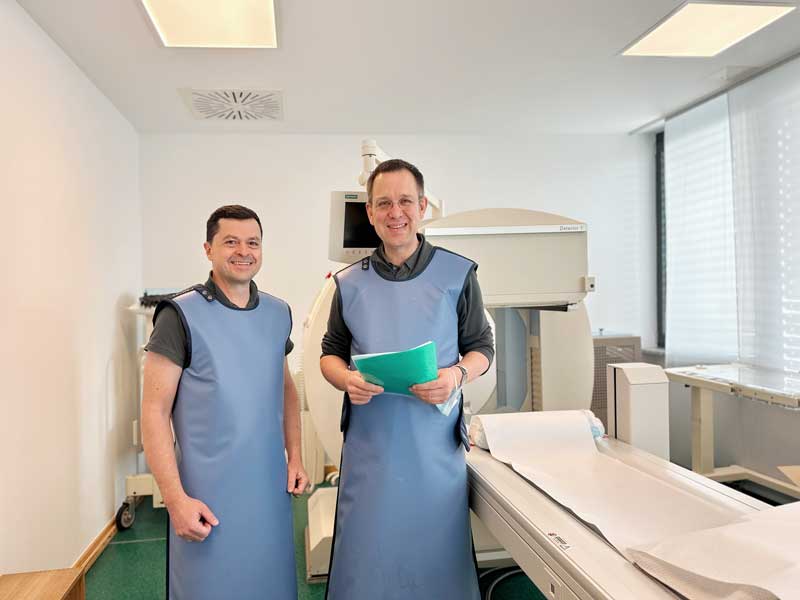 Das Bild zeigt Dr. med Rupert Schmid und Dr. med Martin Henninger im RSO Untersuchungsraum in der Radiologie München Süd West. Unter der Leitung von Dr. Bauer ist die Praxis auf moderne RSO-Diagnostik und strahlungsfreie MRT-Untersuchungen spezialisiert.