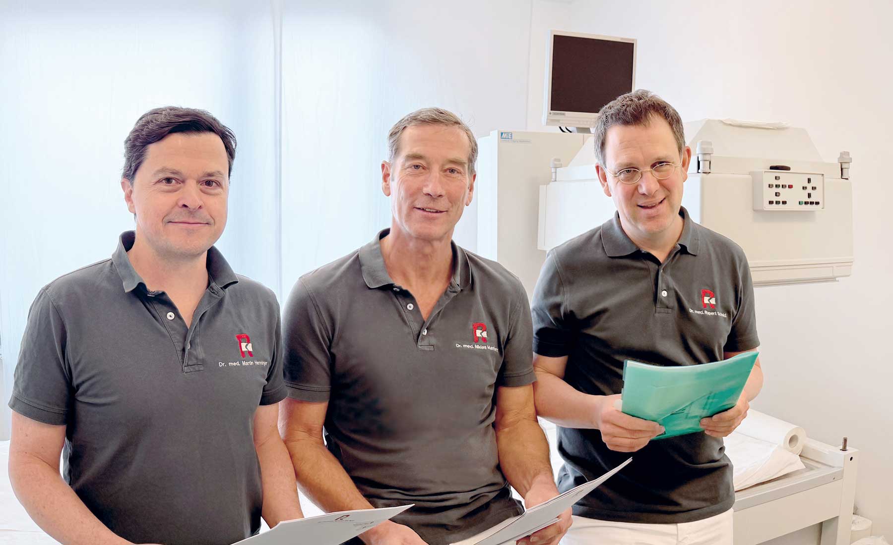 Das Bild zeigt die Ärzte Dr. med. Martin Henninger, Dr. med. Niklas Manthey und Dr. med. Rupert Schmid, die anhand von Patientenunterlagen eine Untersuchung im Bereich RSO Radiosynoviorthese besprechen